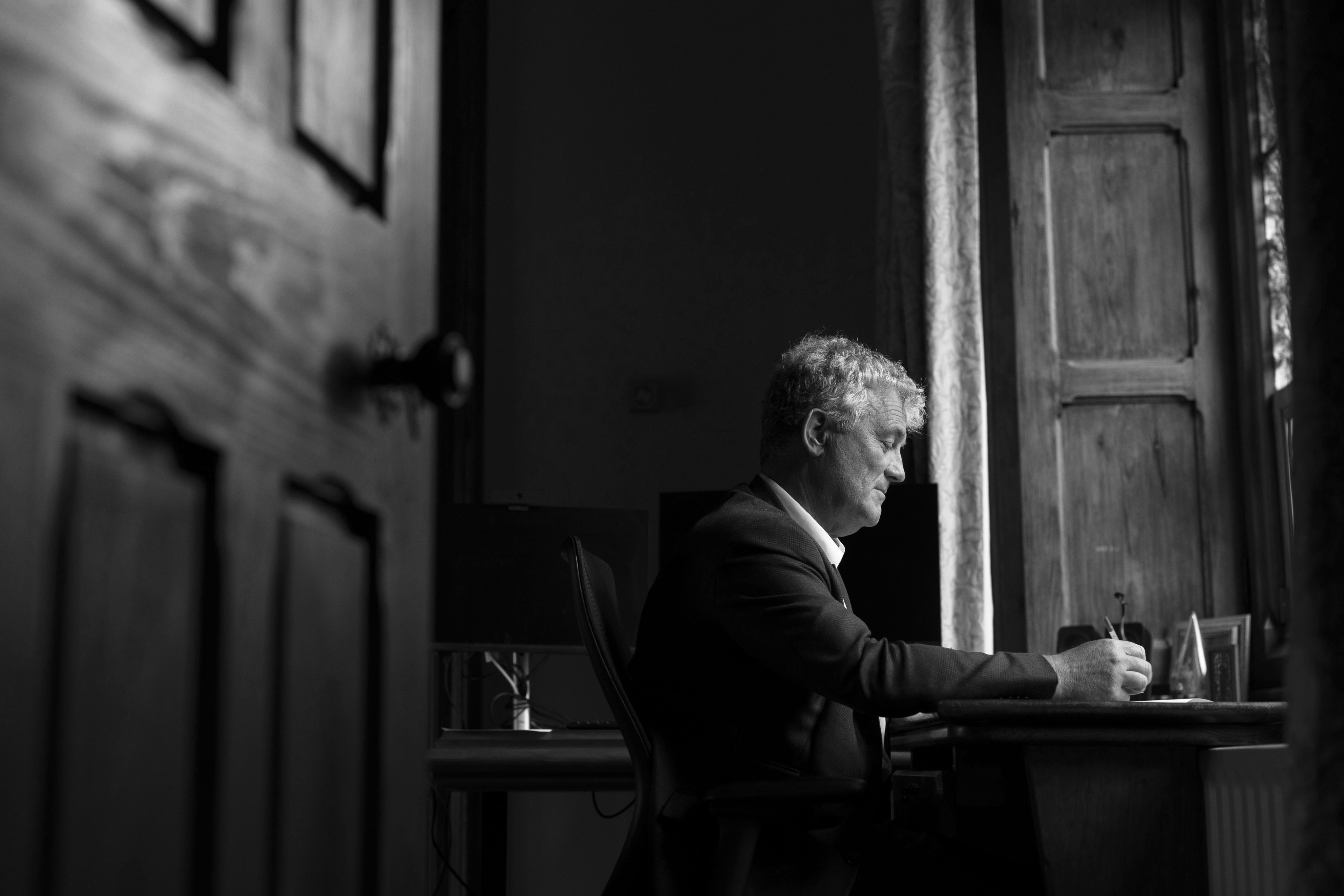 Professor John O'Halloran, President of UCC, writing at his desk 