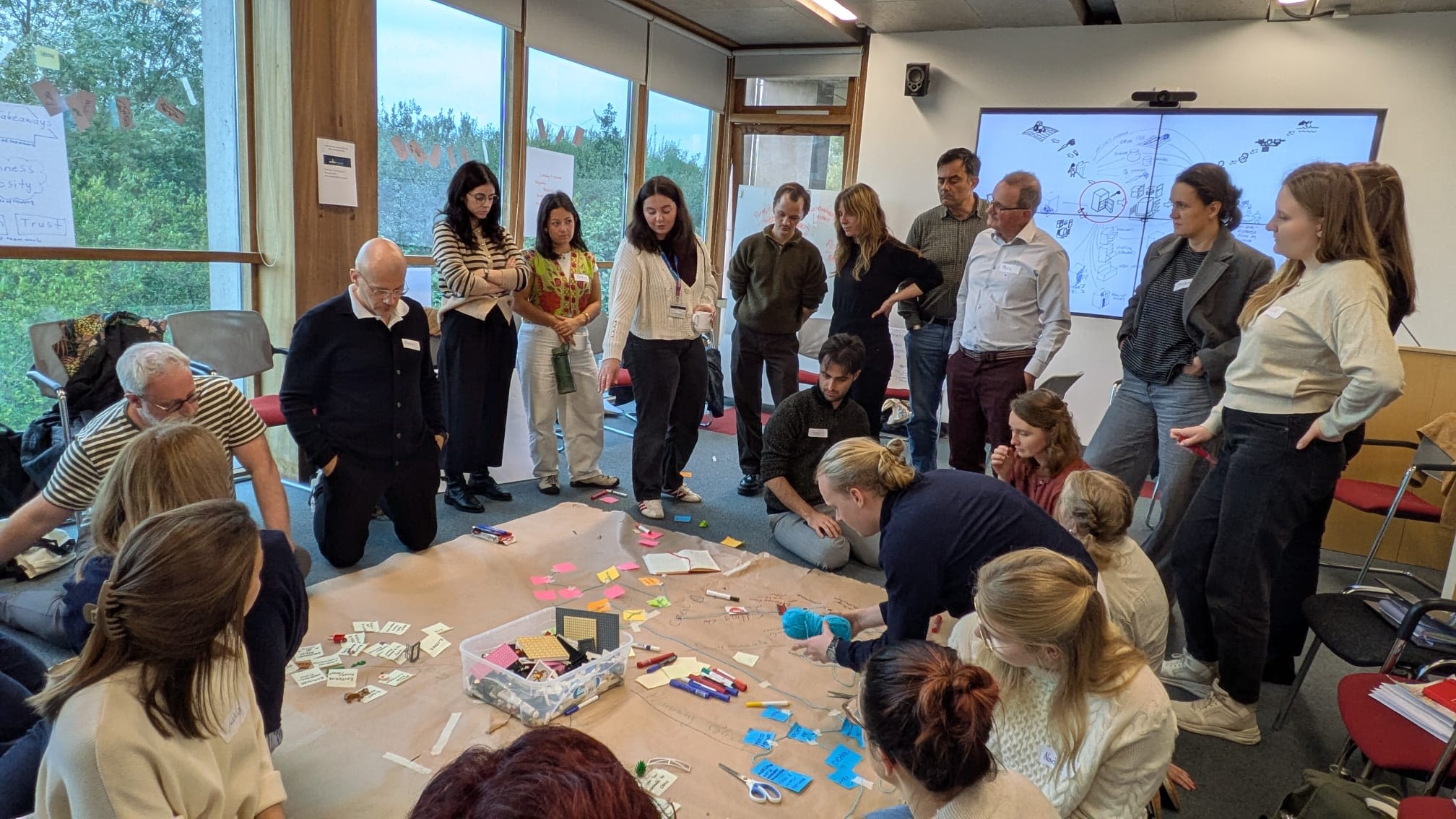 A group of people standing around with post it notes in front of them